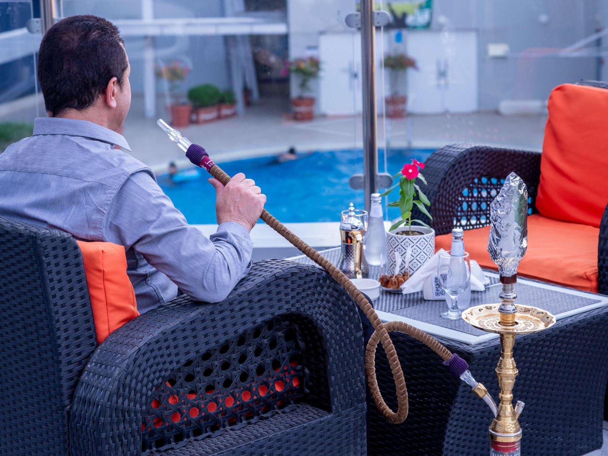 Novotel Jazan Exterior foto A man smoking a hookah