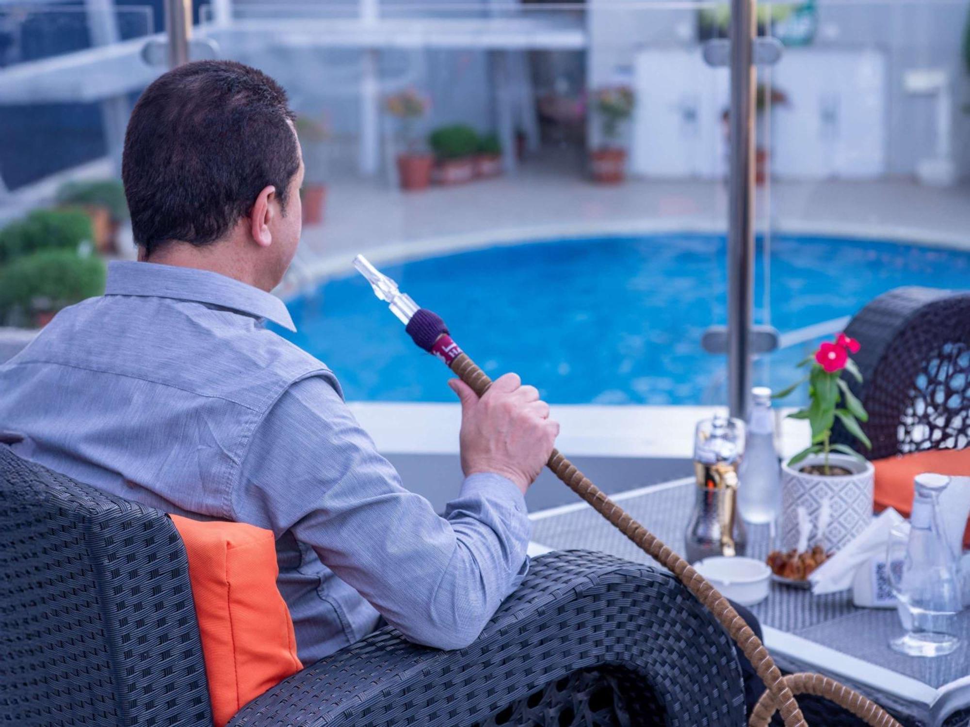 Novotel Jazan Exterior foto A man smoking a hookah